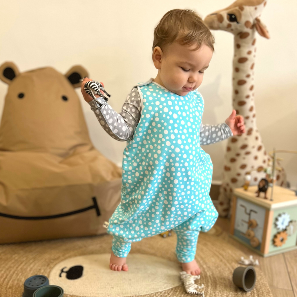 Little baby boy playing in LiaaBébé Toddler Sleeping Bag in Light Blue color with dots.