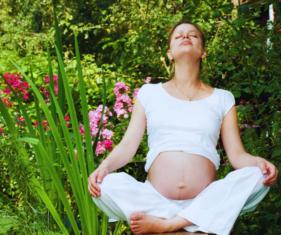 Várandós nő a kertben, növények között meditál
