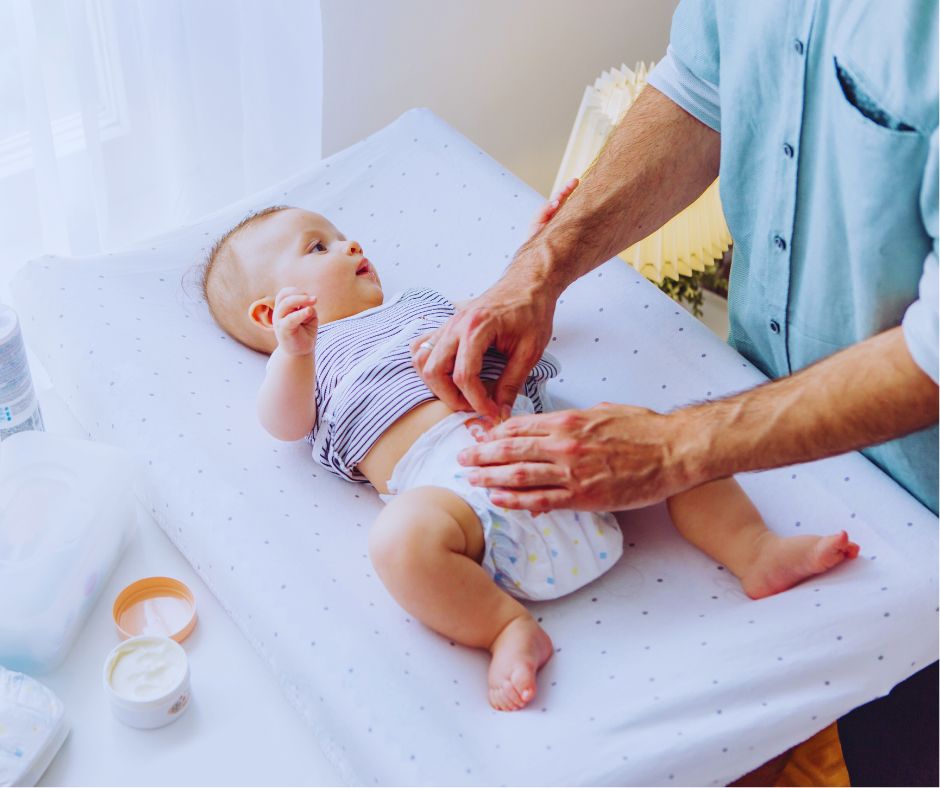 Apa pelenkázza kisbabáját