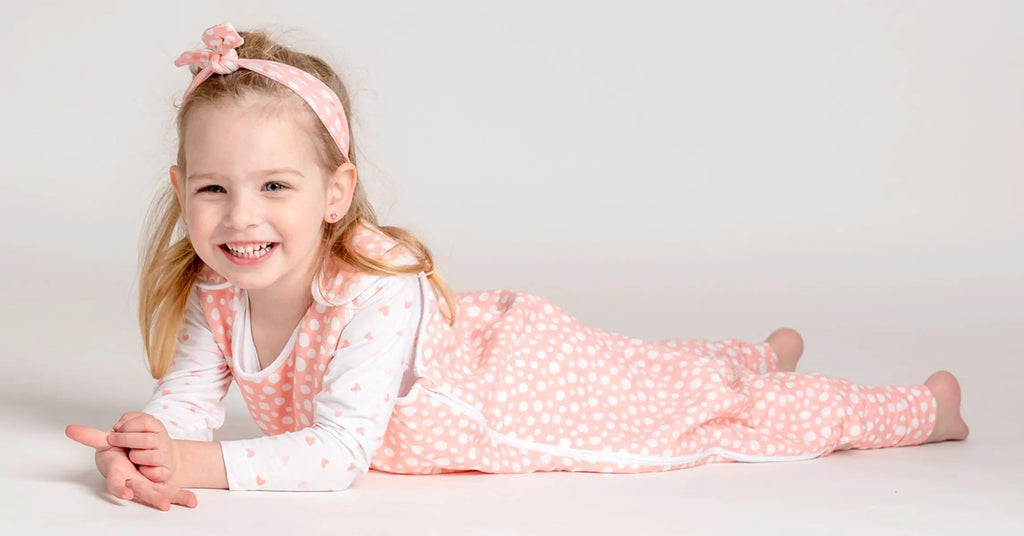 Kislány hasal és moslyog rózsaszn tipegő hálózsákban masnival a fején