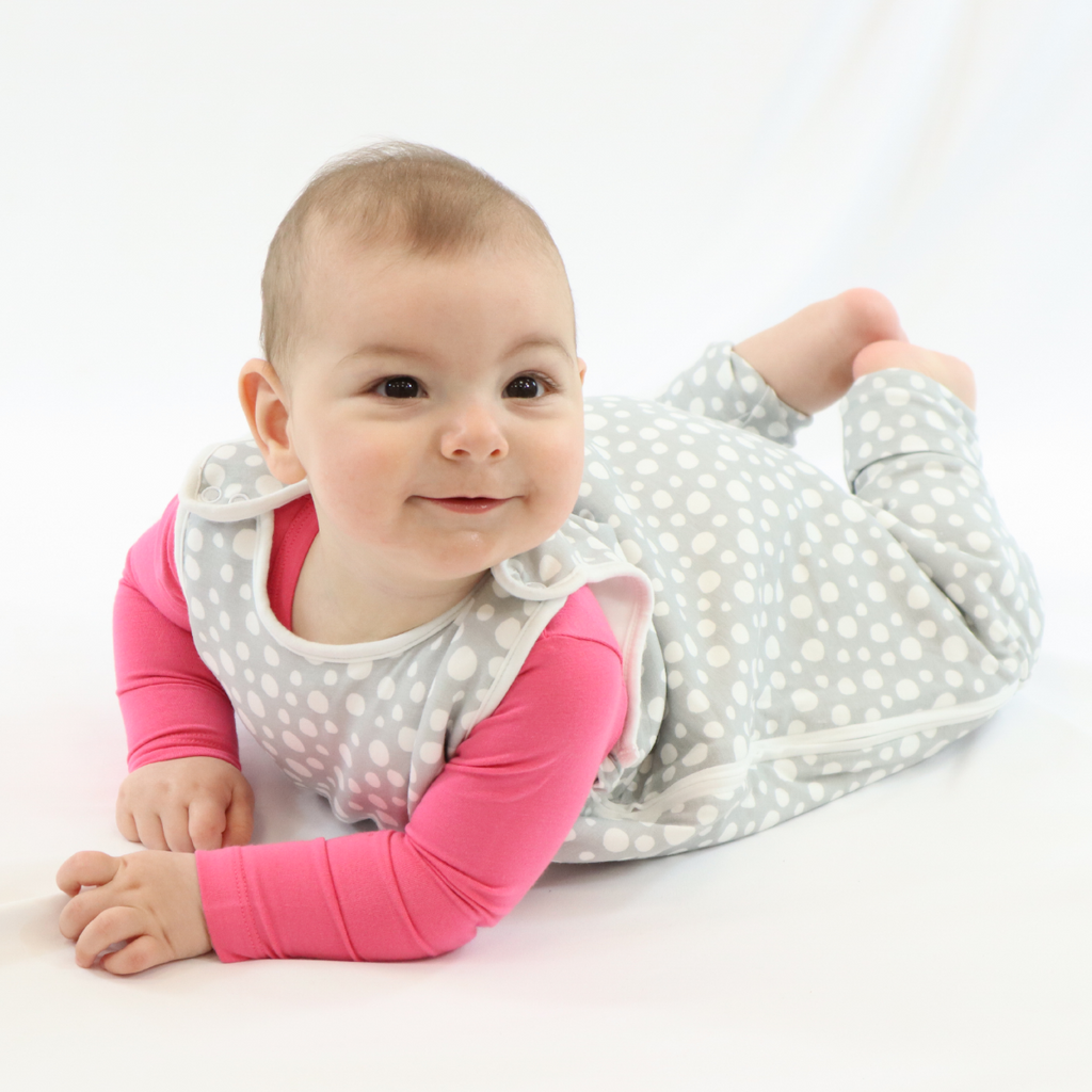 Smiling little baby girl in LiaaBébé Toddler Sleeping Bag in Light Grey color with dots.